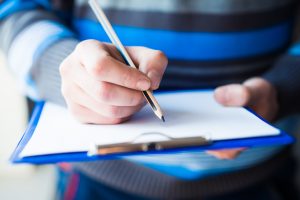 businessman holding a clipboard and write on it